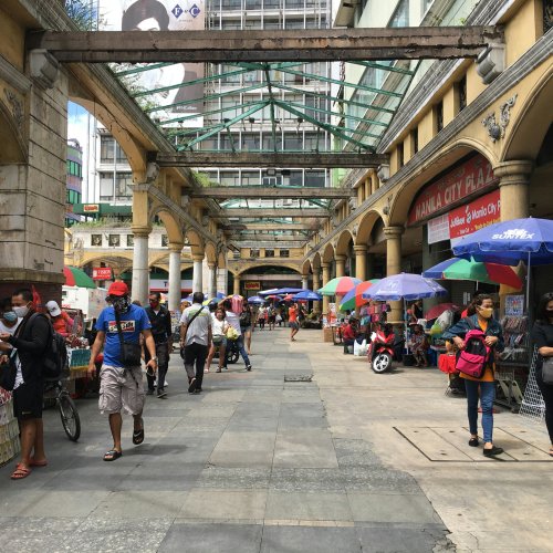 Люди идут по оживленной улице Киапо в Маниле.